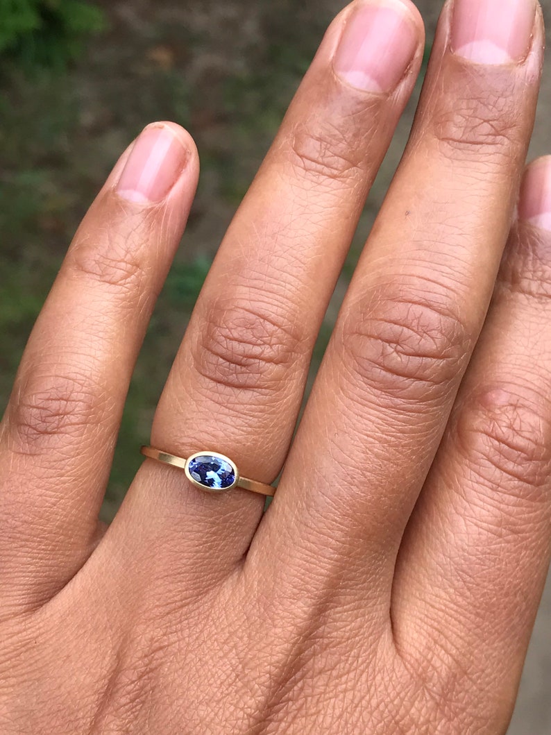 May include: A gold ring with a blue oval gemstone.