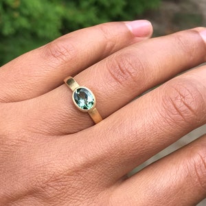 May include: A gold ring with a green oval gemstone.