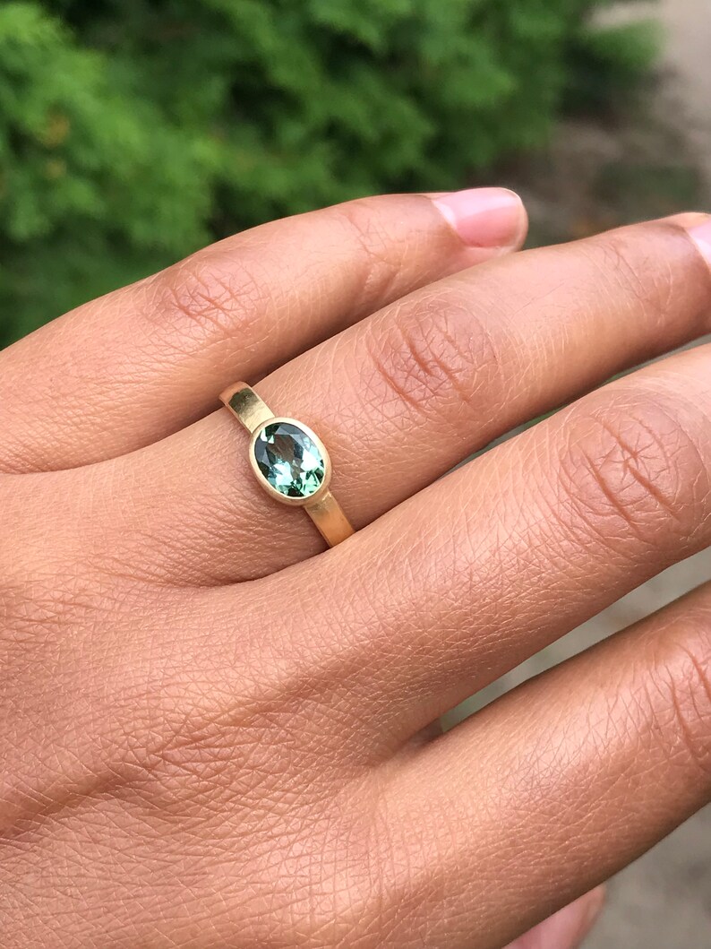 May include: A gold ring with a green oval gemstone.