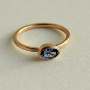 May include: A gold ring with a blue oval gemstone.