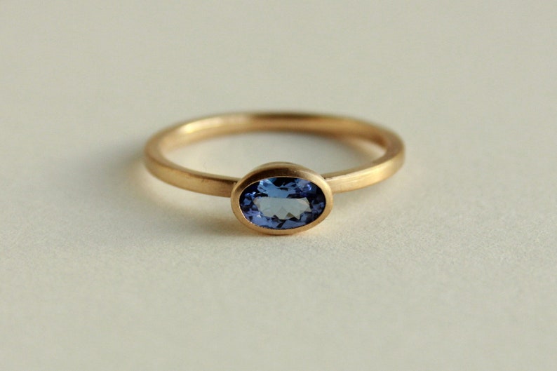 May include: A gold ring with a blue oval gemstone.