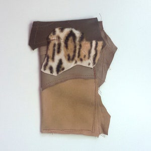 Puede incluir: Un trozo de tela con un patrón de color marrón, tostado y estampado de leopardo. La tela está cosida en un estilo patchwork.