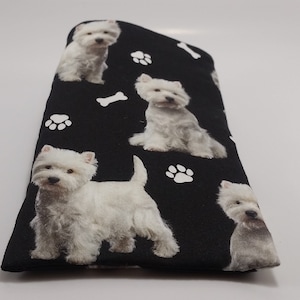 Puede incluir: Estuche para gafas de tela negra con estampado de perro West Highland White Terrier blanco. El estuche está cubierto con un patrón repetido de perro, huellas de patas y huesos.