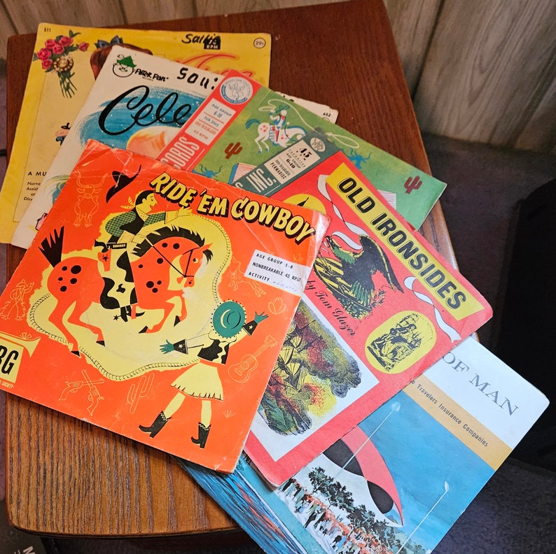 May include: A collection of vintage children's activity books with colorful illustrations. The books feature cowboys, horses, and other western themes. The titles include "Ride 'Em Cowboy", "Old Ironsides", and "Cele Sou's".