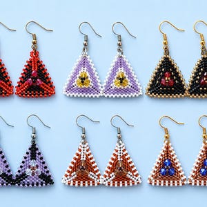 May include: A collection of six pairs of beaded triangle earrings. The earrings feature various color combinations, including red and black, purple and white, and brown and white. Each earring has a hook for easy wear.