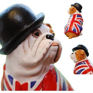 May include: A ceramic bulldog ornament wearing a black bowler hat and a Union Jack vest. The bulldog has a white and tan face with a black nose. The vest features the red, white, and blue flag.