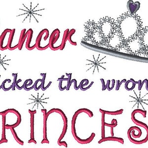 May include: Pink and purple embroidered design with the text "Cancer picked the wrong princess" and a silver crown with a purple heart on top.