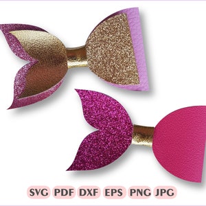 May include: Two glitter mermaid tail hair bows. One bow is pink and gold glitter, the other is pink glitter with a gold centre.