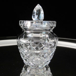 May include: A clear crystal jar with a lid. The jar has a diamond pattern and the lid has a pointed top.