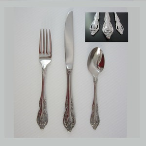 May include: A set of three silver-toned flatware pieces: a fork, a knife, and a spoon. The pieces have an ornate, decorative design.