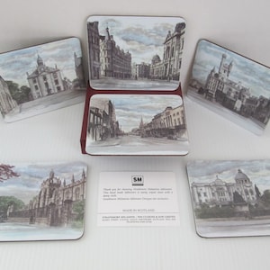 May include: Set of six coasters featuring vintage illustrations of buildings in a city. The coasters are made of cork and have a brown border. The illustrations are in shades of gray and white.