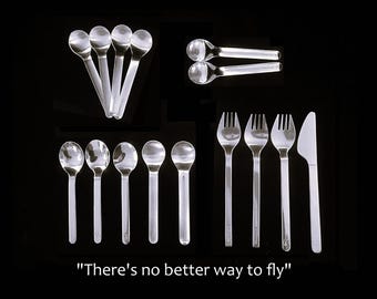 May include: A collection of clear plastic cutlery including nine spoons, three forks, and one knife arranged in groups. The text "There's no better way to fly" is printed at the bottom. The set features a smooth, transparent finish on all pieces.