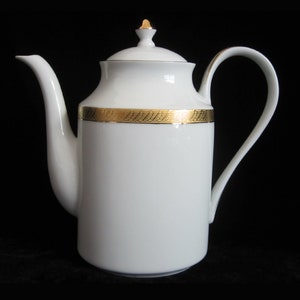 May include: White porcelain teapot with a gold trim around the top. The teapot has a lid and a handle.