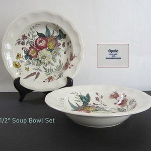 May include: Set of two white 7 1/2 inch soup bowls with a floral pattern in shades of pink, yellow, green, and brown. The bowls are made by Spode, England, and feature the Salisbury pattern.