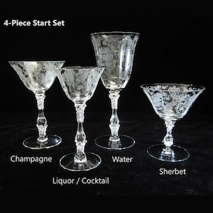 May include: A 4-Piece Start Set of clear, etched glassware. Includes champagne, liquor/cocktail, water, and sherbet glasses. Each glass has a unique shape and decorative stem. The text "4-Piece Start Set" is at the top.