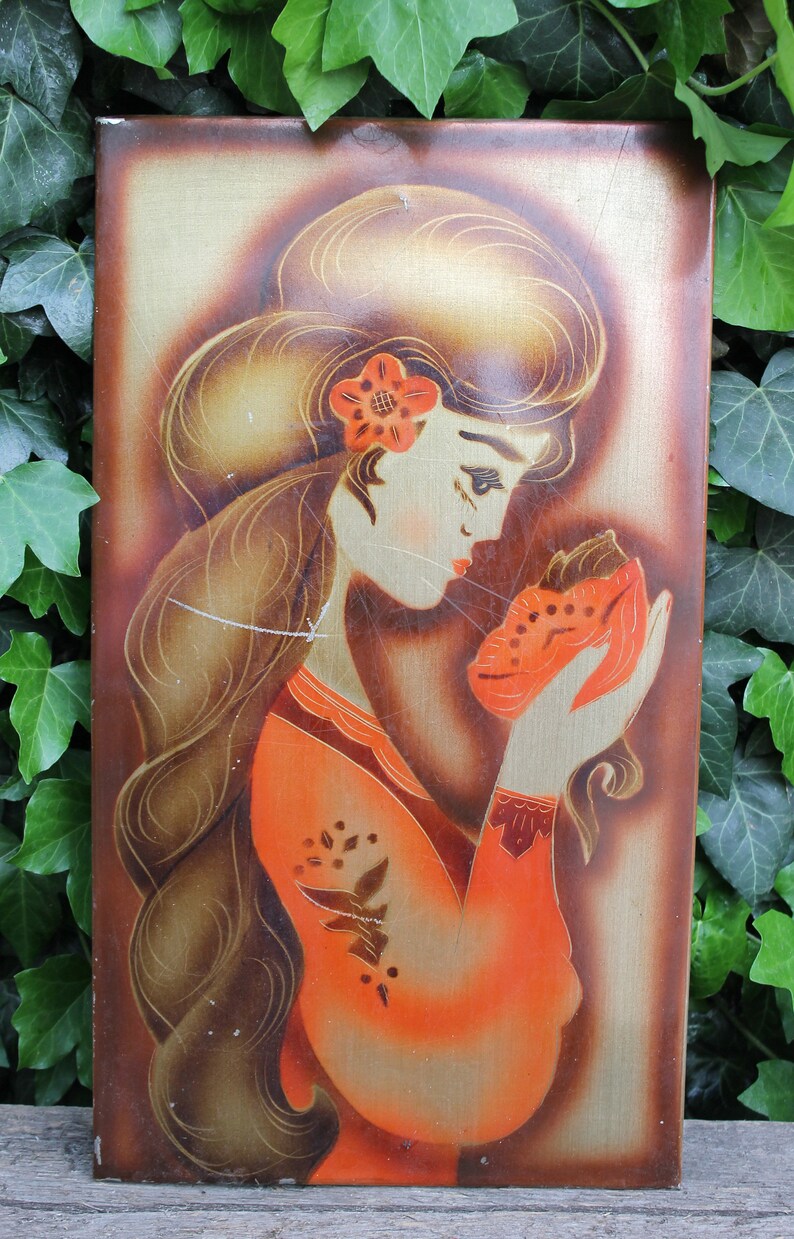 May include: A vintage painting on a wooden panel depicting a woman with long brown hair wearing a red and orange dress. She is holding a small orange object in her hand and looking down at it.