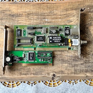 Puede incluir: Dos placas de circuito impreso verdes con varios componentes electrónicos, incluyendo chips y conectores. Una placa tiene el texto "FUNCTION DC0509C2 9533 A" y "Plug and Play Ethernet Card". La otra placa tiene el texto "YSE".