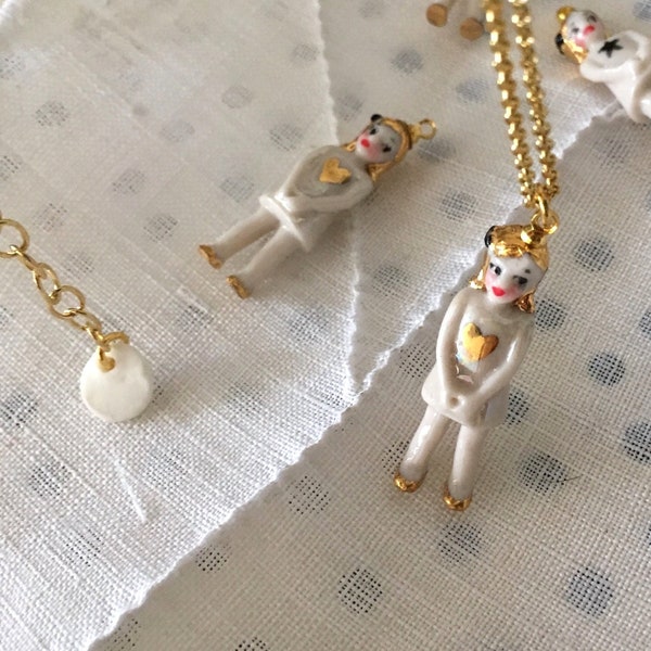 Cute and tiny  porcelain doll necklace with a gold heart and a vermeil chain