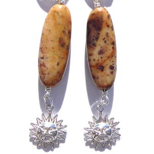 May include: A pair of silver earrings with brown and white agate stones and silver sun charms.