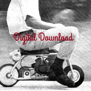 May include: A black and white photo of a young person riding a small, custom-built motorcycle. The motorcycle has a single seat and a small engine. The person is wearing a white shirt and dark pants.