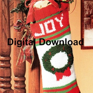 May include: A red and green knitted Christmas stocking with a white wreath and the word "JOY" in white letters.