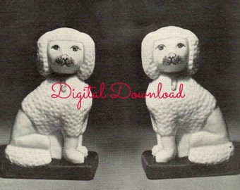 May include: Two white ceramic poodle figurines sitting on black bases. The poodles have black eyes and noses and are in a sitting position.