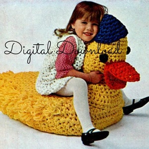 May include: A crocheted yellow duck with a red beak and blue and white hat. A young girl is sitting on the duck, wearing a white and pink crocheted vest and white tights.