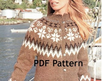 Puede incluir: Un cárdigan de punto marrón con un patrón de copo de nieve blanco y cierre de botones. El cárdigan se muestra en una modelo que lo lleva con pantalones blancos. El texto "PDF Pattern" está superpuesto a la imagen.