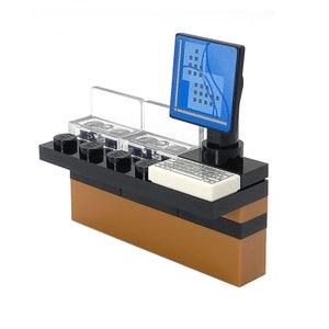 Könnte beinhalten: Ein schwarzer und brauner Lego-Schreibtisch mit einem Computermonitor, einer Tastatur und durchsichtigen Plastik-Schubladen. Der Computermonitor hat einen blauen Bildschirm mit einem Muster aus Quadraten und Linien.