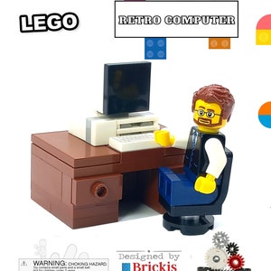 Op de afbeelding: Een LEGO® MOC Bricks ontwerp van een retrocomputer met een minifiguur die aan een bureau zit. De computer heeft een zwart scherm, een wit toetsenbord en een printer. De minifiguur draagt een blauw shirt, een zwarte stropdas en een bril. Het bureau is bruin en heeft een lade. Het ontwerp is gemaakt met echte LEGO® stenen en onderdelen. De afbeelding bevat ook de tekst "WARNING: CHOKING HAZARD. Toy contains small parts and a small ball. Not for children under 3 years." en "Designed by Brickis".