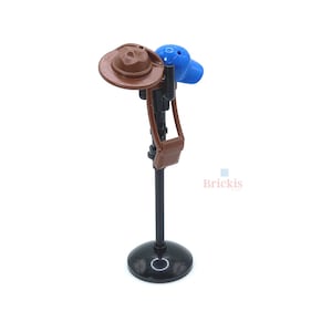 Può includere: Un supporto nero con un cappello marrone e un berretto blu in cima. Il supporto ha una borsa di pelle marrone attaccata ad esso.