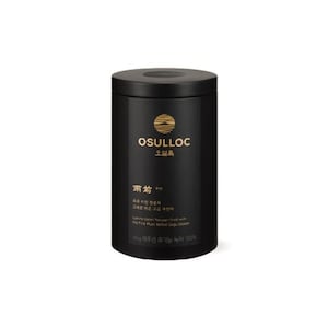 May include: A cylindrical black tea canister with a matte finish. The front features a gold circular logo, the text OSULLOC, and additional Korean and English text. The container has a flat lid and a clean, minimalist design for storing tea leaves.