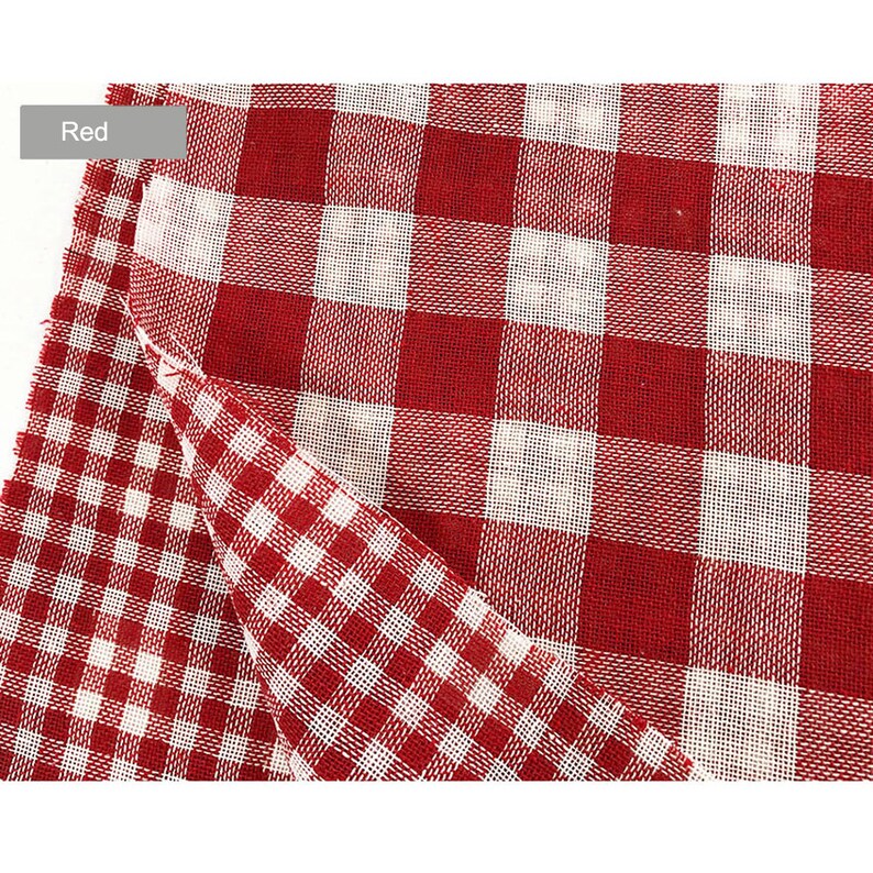 May include: Red and white gingham fabric with a checkered pattern. The fabric is folded in half, showing both sides of the pattern.