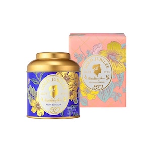 Könnte beinhalten: Eine blaue Teedose mit goldenem Deckel, verziert mit goldenen Blumenmustern und dem Text "GOLD JUBILEE" und "PLUM BLOSSOM". Daneben eine rosa Schachtel mit goldenen Blumenmustern und dem Text "GOLD JUBILEE 50TH ANNIVERSARY".
