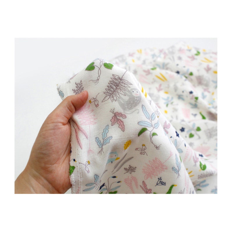 May include: White cotton fabric with a repeating pattern of pink, blue, green, and yellow leaves, flowers, and small birds. A gray sloth is featured in the pattern.