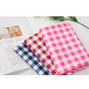May include: Three fabric swatches with a gingham pattern. The swatches are pink and white, red and white, and blue and white.