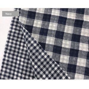 May include: Navy blue and white gingham fabric with a checkered pattern. The fabric is folded in half, showing both sides of the pattern.