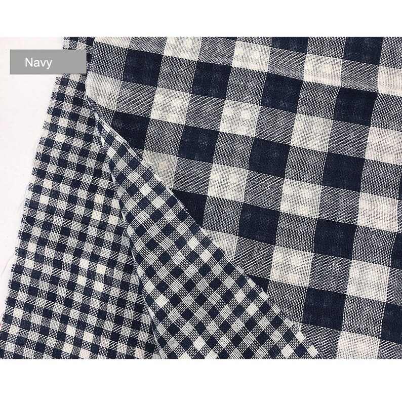 May include: Navy blue and white gingham fabric with a checkered pattern. The fabric is folded in half, showing both sides of the pattern.