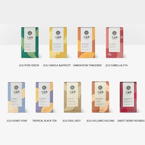 May include: Ten different boxes of tea with various flavors, including Jeju Pure Green, Jeju Canola & Apricot, Samdayeon Tangerine, Jeju Camellia Eta, Jeju Honey Pear, Tropical Black Tea, Jeju Earl Grey, Jeju Volcanic Oolong, and Sweet Berry Rooibos. Each box features a unique design with a green, yellow, orange, red, blue, purple, brown, or pink background.