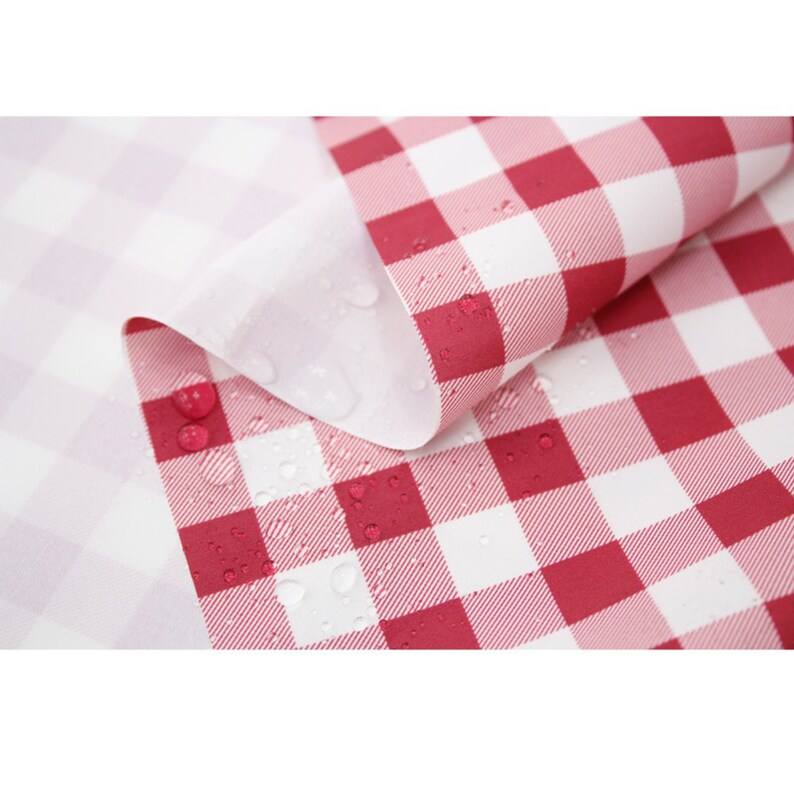 May include: Red and white checkered fabric with water droplets on the surface. The fabric is waterproof and is ideal for outdoor use.