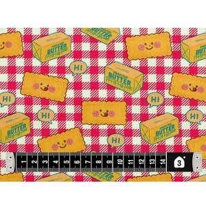 May include: Fabric with a repeating pattern of smiling cartoon crackers, butter boxes, and speech bubbles with "HI" on a red and white checkered background. A measuring tape shows 3 inches.