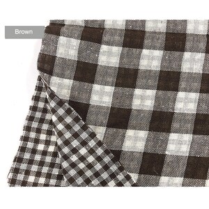 May include: Brown and white checkered fabric with a slightly different pattern on the bottom half. The fabric is folded over on itself.