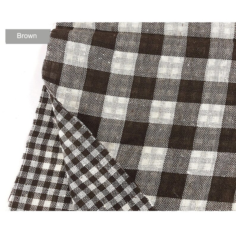 May include: Brown and white checkered fabric with a slightly different pattern on the bottom half. The fabric is folded over on itself.