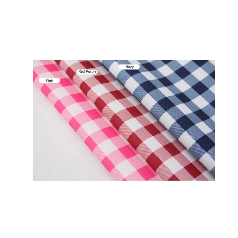May include: Three fabric swatches in pink, red purple, and navy blue with a white gingham pattern. The swatches are folded over each other.