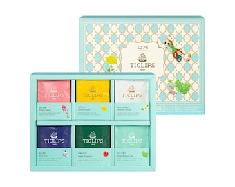 Könnte beinhalten: Ein türkisfarbenes Geschenkset mit Ticlips-Tee. Das Set enthält eine Vielzahl von Teesorten in einzelnen Beuteln, jeweils in einer anderen Farbe. Die Box hat ein dekoratives Muster und das Ticlips-Logo.