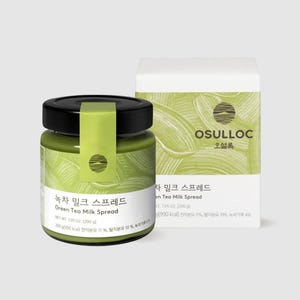 Peut inclure: Un pot en verre de tartinade au lait de thé vert avec un couvercle noir et une étiquette verte et blanche. L'étiquette indique "녹차 밀크 스프레드 Green Tea Milk Spread" et "NET WT 7.05 oz (200 g)". Le pot est posé sur une surface blanche devant une boîte blanche avec une étiquette verte et blanche qui indique "OSULLOC 오설록" et "녹차 밀크 스프레드 Green Tea Milk Spread".