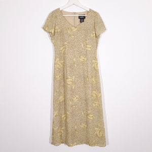 May include: A beige maxi dress with a floral print and a V-neckline. The dress has short sleeves and a fitted bodice.