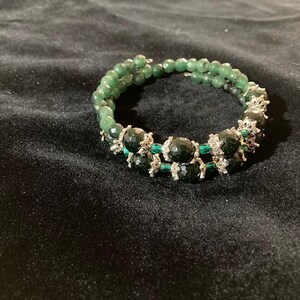 May include: A double-strand bracelet with dark green beads and silver accents.