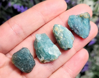 May include: Five rough, green and blue gemstone crystals. The crystals are various sizes and shapes.