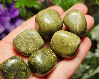 May include: Six smooth, green tumbled stones with a mottled, marbled appearance. The stones are arranged in a hand, with the largest stone in the center.